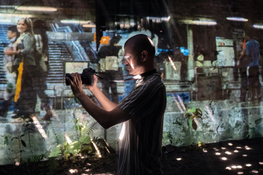 Colombian visual artist Mauricio Carmona Rivera working with a camera in an installation