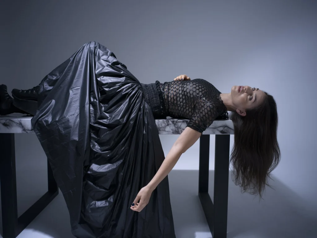 Lithuanian soprano Asmik Grigorian reclining in a black dress on a marble table, photographed by Timofey Kolesnikov for Alpha Classics.