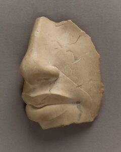 Limestone fragment preserving the nose and lips of Akhenaten, exhibited in Broken at Palazzo Strozzi