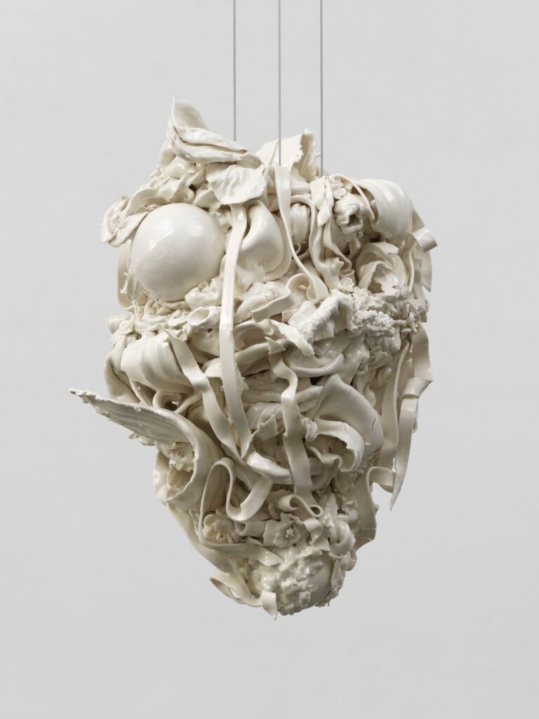 White porcelain sculpture Pull (2023) by Rachel Kneebone, intricate suspended forms against a light grey background.