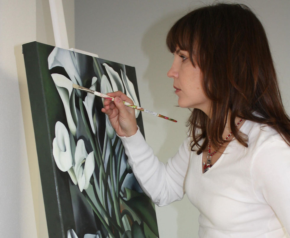 Elena Lagun painting at an easel in her studio